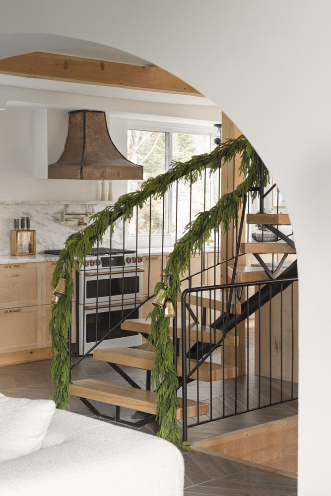 Guirlandes de cyprès sur les rampes d'escalier d'un chalet chaleureux - Décors Véronneau