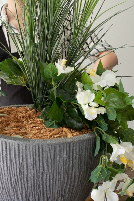 Fleuriste en train de créer un arrangement floral extérieur - Décors Véronneau