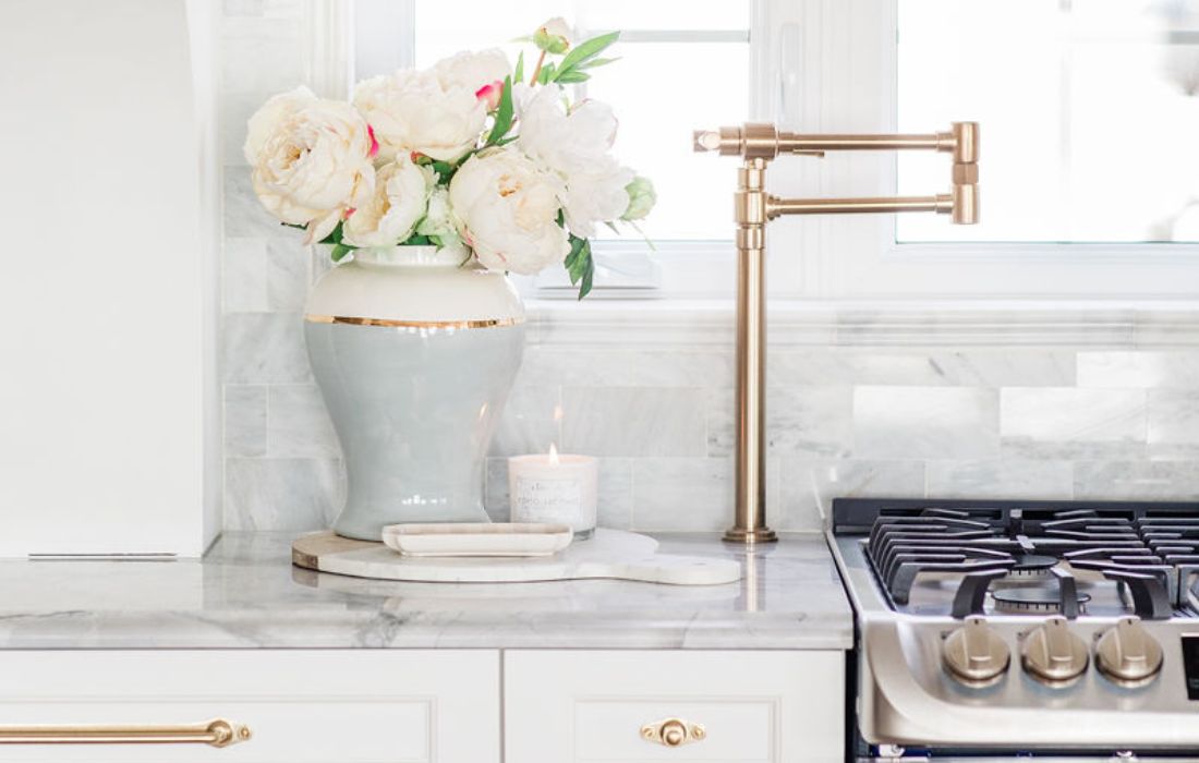 Arrangement de pivoines roses dans une cuisine blanche avec poignées en laiton - Décors Véronneau