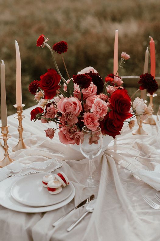 Centre de table avec roses rouges et chandeliers à un mariage - Décors Véronneau