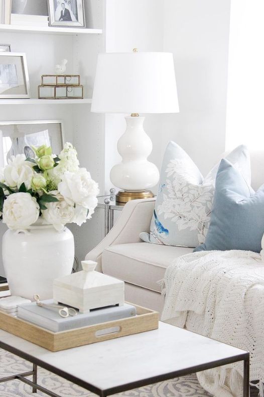 Salon avec sofa de coussins bleus et fleurs blanches en vase - Décors Véronneau