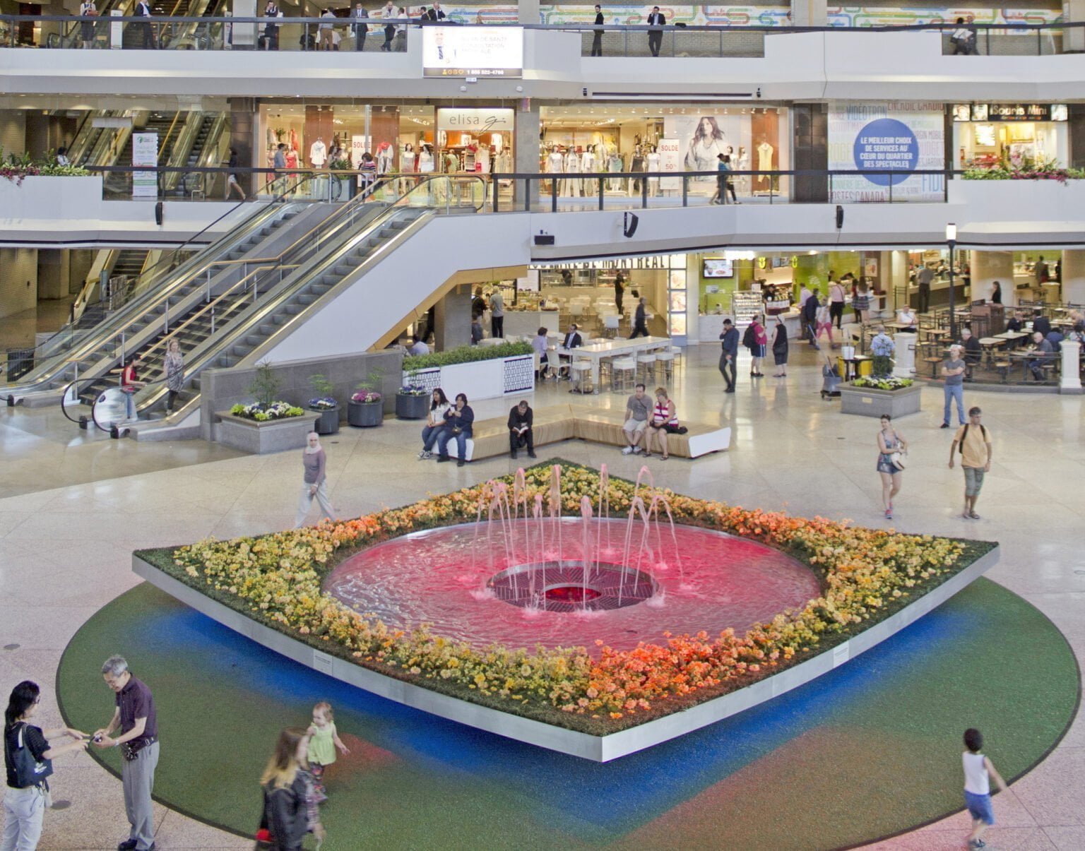 Compositions de fleurs et de verdure artificielles autour de la grande fontaine au Complexe Desjardins - Décors Véronneau