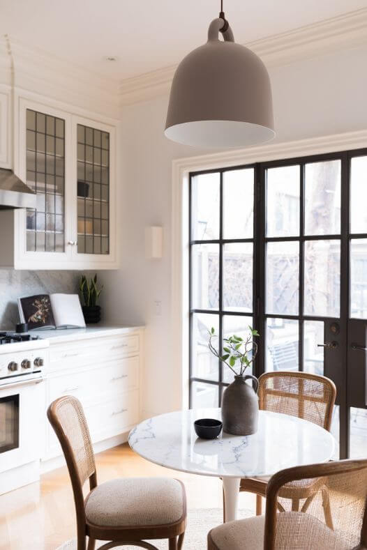 Table à café avec branche de verdure dans une cuisine blanche - Décors Véronneau