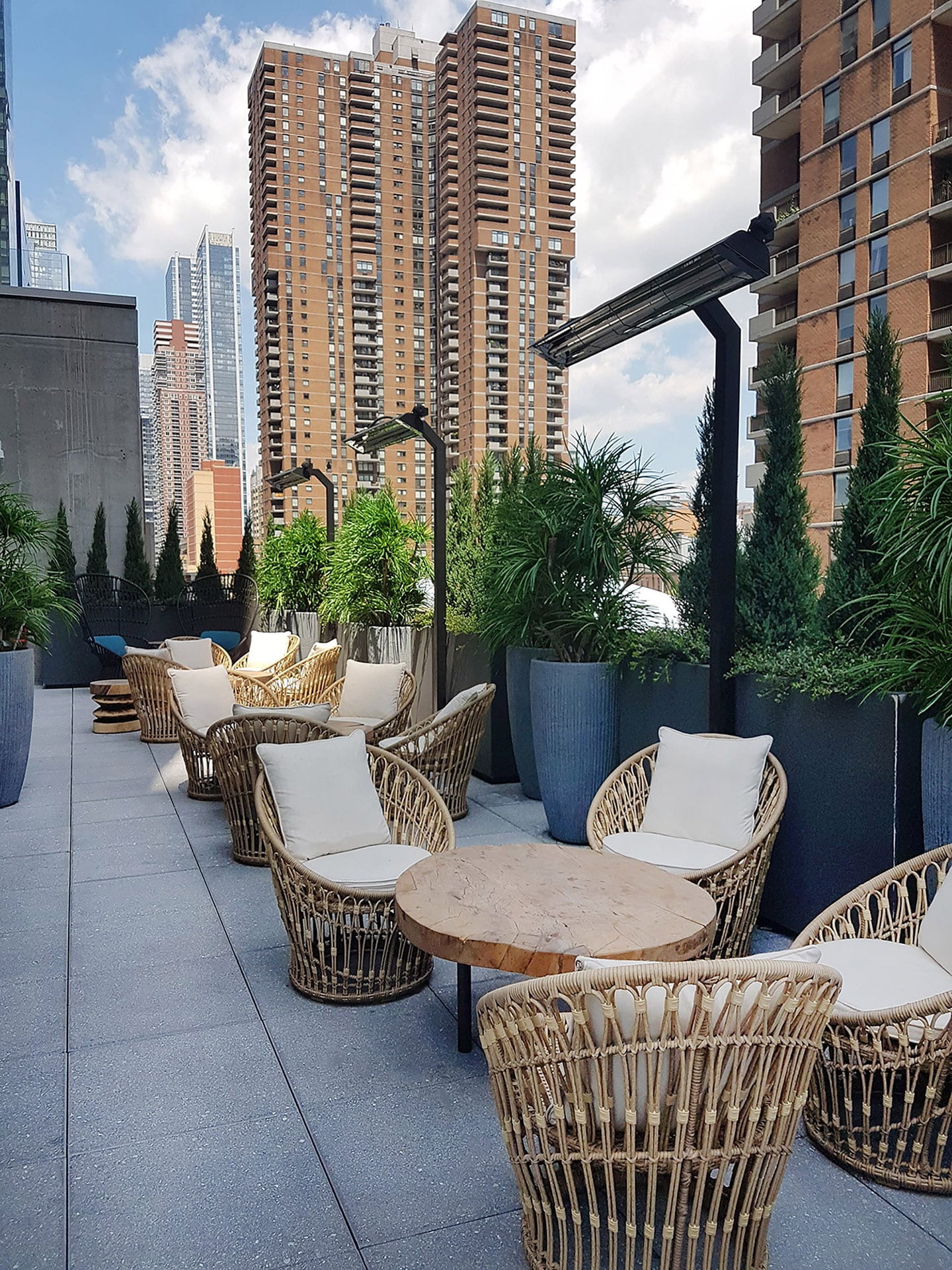 Aménagement de cette terrasse incluant des arbres artificiels de type raintree, ainsi que des cèdres artificiel dans des bacs et des pots foncés. - Décors Véronneau