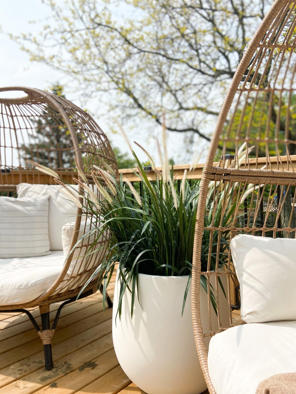 Graminées artificielles dans un pot blanc avec des chaises oeuf. - Décors Véronneau