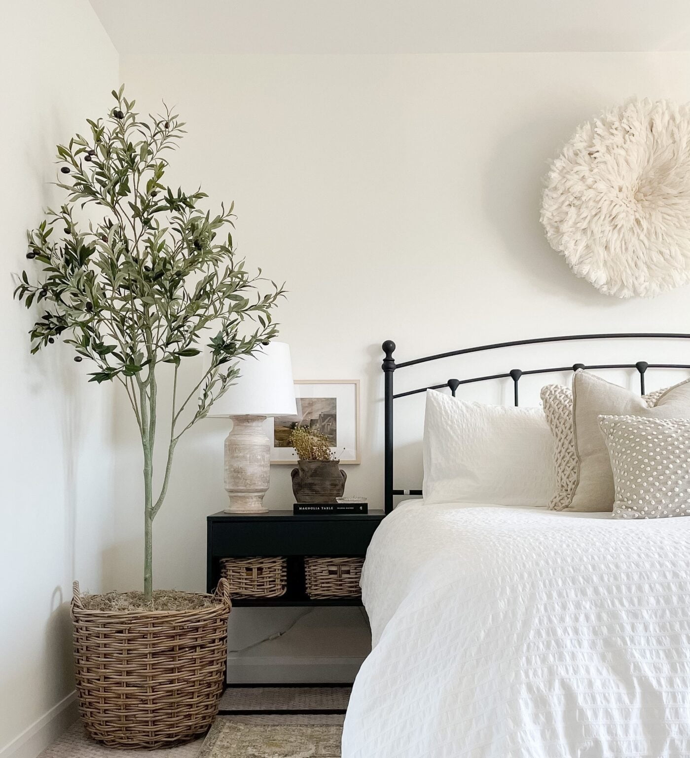 Olivier artificiel dans un panier dans une chambre à coucher blanche - Décors Véronneau