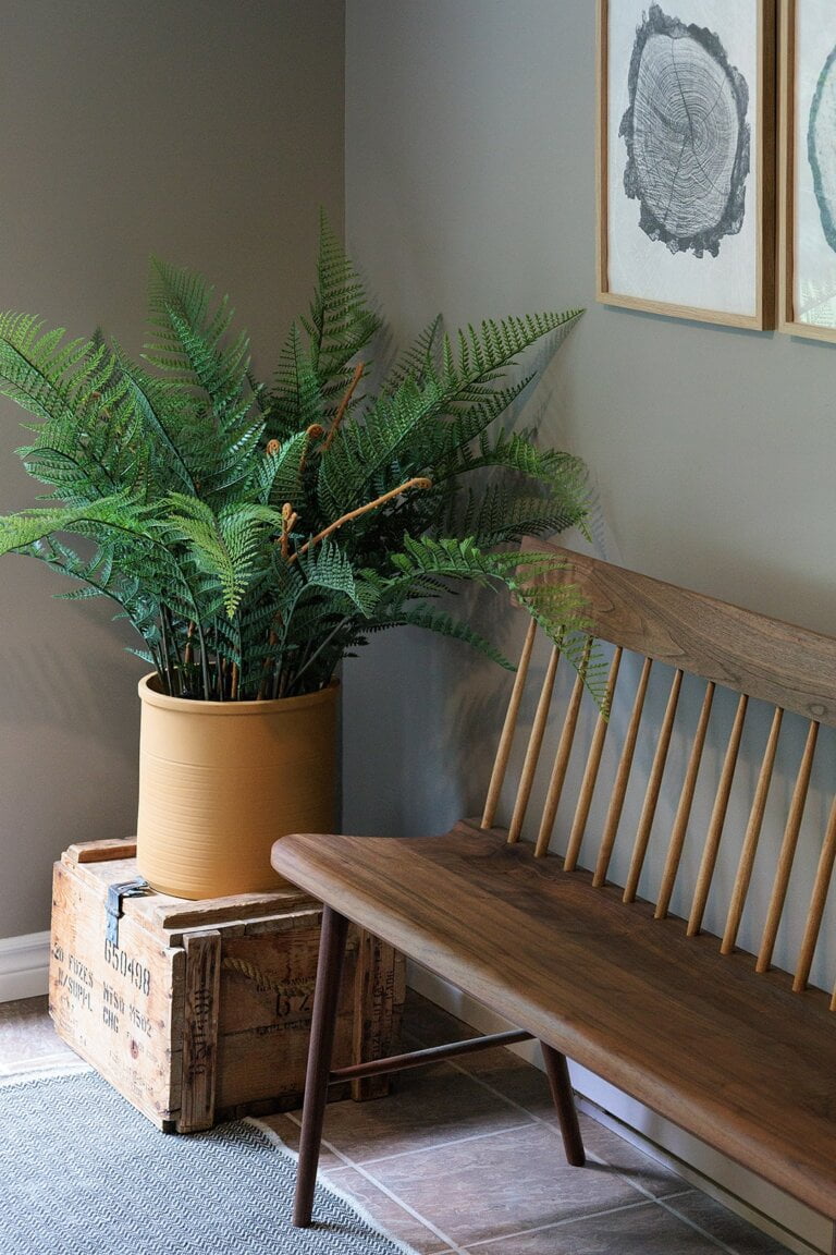 Fougère verte artificielle avec pot orange et banc en bois