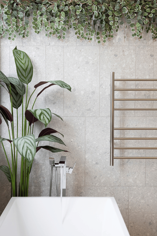 Robinet chrome dans une salle de bain avec plante - Décors Véronneau