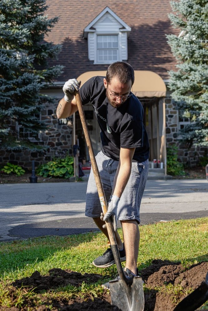 Homme qui creuse un trou pour y planter un arbre - Décors Véronneau