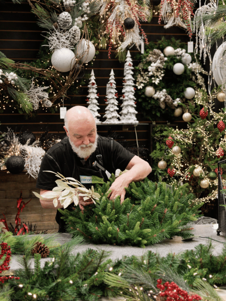 Fleuriste qui décore une couronne de Noël - Décors Véronneau