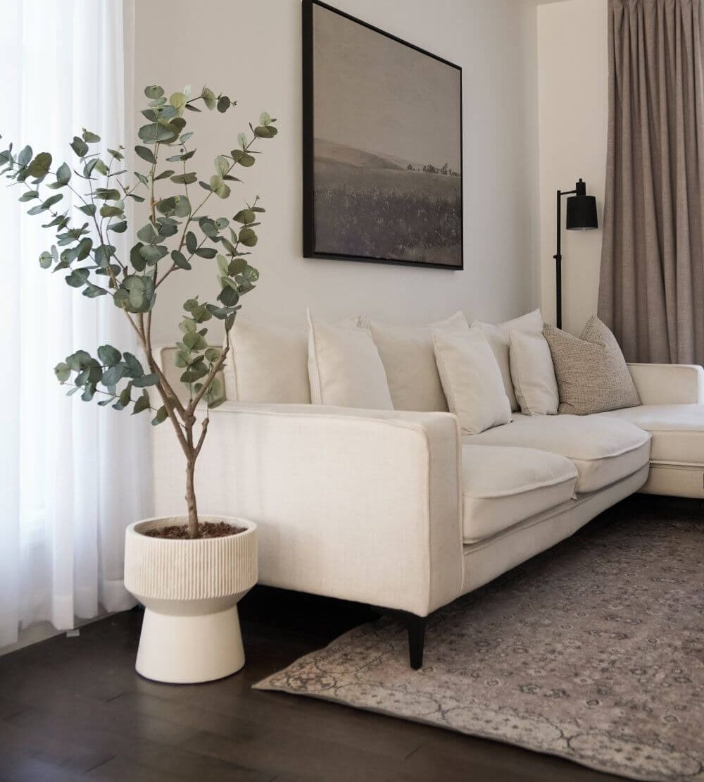 Buisson d'eucalyptus artificiel en pot blanc dans un salon - Décors Véronneau