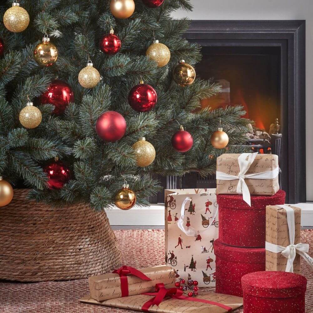 Cache-pied de sapin de Noël en jute avec ornements rouges et dorés et cadeaux - Décors Véronneau