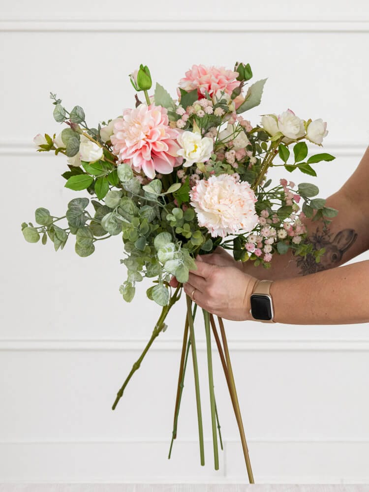 Bouquet de fleurs artificielles et eucalyptus dans les mains d'une personne - Décors Véronneau
