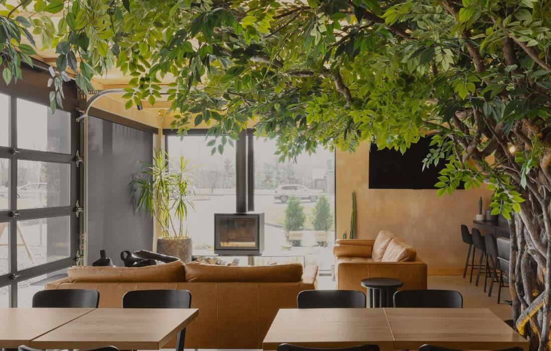 Arbre artificiel et plantes naturelles dont un cactus près d'un foyer - Décors Véronneau